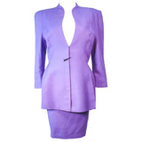 This Thierry Mugler skirt suit is composed of a lavender/purple hue fabric. Features a classic Mugler silhouette with nipped waist and curved bust-line to neckline design. The classic pencil style skirt features a zipper closure. In good vintage pre-owned condition (some signs of wear due to age) the skirt shows signs of alterations. Made in France.