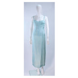 This Christian Dior gown is composed of an aqua crepe silk with as silk satin slip. Features an asymmetrical design with a side zipper. In excellent vintage condition, there are some signs of wear due to age. 