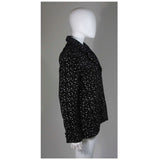 This Giorgio Armani jacket is composed of a wool blend in a black with white speckle textile print. There are front pockets, front button closures, and piping trim. In excellent condition. Made in Italy.