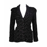 This Giorgio Armani jacket is composed of a wool blend in a black with white speckle textile print. There are front pockets, front button closures, and piping trim. In excellent condition. Made in Italy.