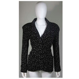 This Giorgio Armani jacket is composed of a wool blend in a black with white speckle textile print. There are front pockets, front button closures, and piping trim. In excellent condition. Made in Italy.