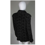 This Giorgio Armani jacket is composed of a wool blend in a black with white speckle textile print. There are front pockets, front button closures, and piping trim. In excellent condition. Made in Italy.
