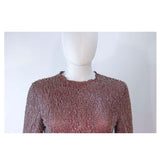 GIORGIO ARMANI Pink Mauve Silk Pant Suit with Beaded Mesh Body Suit Size 42. This Giorgio Armani pant suit is composed of a pink mauve hue silk, comes with a brown beaded mesh bodysuit. The jacket has a center front button closure, and the pants feature a zipper closure. In excellent condition