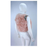 This Givenchy jacket is composed of a soft mauve pink marabou and features rhinestone jewel accents at the shoulders. The base is composed of silk and features a silk organza interior. In excellent condition.