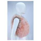 This Givenchy jacket is composed of a soft mauve pink marabou and features rhinestone jewel accents at the shoulders. The base is composed of silk and features a silk organza interior. In excellent condition.