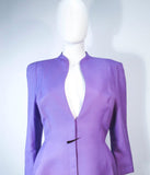 This Thierry Mugler skirt suit is composed of a lavender/purple hue fabric. Features a classic Mugler silhouette with nipped waist and curved bust-line to neckline design. The classic pencil style skirt features a zipper closure. In good vintage pre-owned condition (some signs of wear due to age) the skirt shows signs of alterations. Made in France.