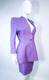 This Thierry Mugler skirt suit is composed of a lavender/purple hue fabric. Features a classic Mugler silhouette with nipped waist and curved bust-line to neckline design. The classic pencil style skirt features a zipper closure. In good vintage pre-owned condition (some signs of wear due to age) the skirt shows signs of alterations. Made in France.