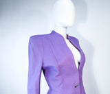 This Thierry Mugler skirt suit is composed of a lavender/purple hue fabric. Features a classic Mugler silhouette with nipped waist and curved bust-line to neckline design. The classic pencil style skirt features a zipper closure. In good vintage pre-owned condition (some signs of wear due to age) the skirt shows signs of alterations. Made in France.