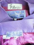 This Thierry Mugler skirt suit is composed of a lavender/purple hue fabric. Features a classic Mugler silhouette with nipped waist and curved bust-line to neckline design. The classic pencil style skirt features a zipper closure. In good vintage pre-owned condition (some signs of wear due to age) the skirt shows signs of alterations. Made in France.