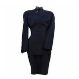 This THIERRY MUGLER skirt suit is composed of a black polyester and lace fabric. Features a classic Mugler silhouette with nipped waist and curved bust-line to neckline design. The jacket has front snap closures, rounded shoulders, and lace panels at the neck, back, and sleeves. The classic pencil style skirt features a zipper closure. In good vintage pre-owned condition. Made in France.Measurements in Inches:JacketBust: 38 Waist: 30 SkirtWaist: 27Hip: 38Length: 22