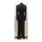 THIERRY MUGLER Black and White Stitched Pinstripe Pant Suit Size 40. This THIERRY MUGLER pant suit is composed of a wool pinstripe fabric. Features a classic Mugler silhouette with nipped waist and curved bust-line to neckline design. The jacket has front snap closures, rounded shoulders, and silver bar buttons. The classic pants features a zipper closure. In good vintage pre-owned condition. Made in France.Measurements in Inches:JacketBust: 40Waist: 32 PantsWaist: 27Hip: 40Length: 40Inseam: 29.5