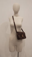 HERMÈS Dark Brown Leather Crossbody Bag with Gold Buckle and Adjustable Strap