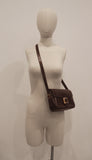 HERMÈS Dark Brown Leather Crossbody Bag with Gold Buckle and Adjustable Strap