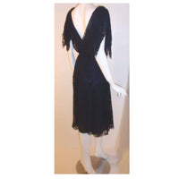 This is a navy blue three layer chiffon swirl print cocktail dress by Christian Dior Haute Couture, from the early 1980's. The dress has a deep v in the front and the back, knots at the top of each shoulder, and a side zipper with snaps. Provenance Betsy Bloomingdale