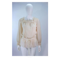 This Christian Dior Couture ensemble is composed of a raw silk chiffon in a natural nude hue. Features a peasant style blouse with ruffle and satin trim, there are side snap closures with hook and eyes. The skirt has a pleated style with side zipper closure.