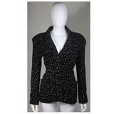 This Giorgio Armani jacket is composed of a wool blend in a black with white speckle textile print. There are front pockets, front button closures, and piping trim. In excellent condition. Made in Italy.