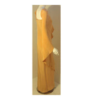 This is a vintage long peach silk gown by Givenchy, from the 1970's. The gown has a constructed bodice and a draped sleeve over the shoulder.  Provenance: Betsy Bloomingdale