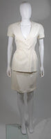 This Thierry Mugler skirt suit is composed of a white material. The jacket has a center front closures with silver hardware. The skirt has a classic pencil silhouette with zipper closure. In excellent vintage condition. Made in France.