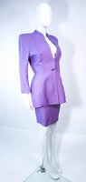 This Thierry Mugler skirt suit is composed of a lavender/purple hue fabric. Features a classic Mugler silhouette with nipped waist and curved bust-line to neckline design. The classic pencil style skirt features a zipper closure. In good vintage pre-owned condition (some signs of wear due to age) the skirt shows signs of alterations. Made in France.