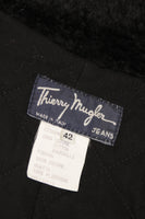This Thierry Mugler jacket is composed of a blue jean with black faux fur collar and features center front snap front closures. There are shoulder pads. Made in France. Measures (Approximately)