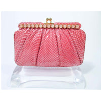 JUDITH LEIBER Pink Snakeskin Clutch w/ Optional Strap Mirror Coin Purse . This Judith Leiber purse is composed of a pink snakeskin. Features a bar style frame with cabochon stone accents and gold hardware. There is an interior pocket and two slide pockets. In excellent 'like new' pre-owned condition (some signs of wear due to age, see photos). Sold "AS-IS". 