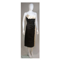 This Oleg Cassini cocktail dress is composed of black and off-white silk with lace applique. There is a center back zipper closure. and spaghetti strap. In excellent vintage condition. 