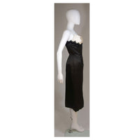 This Oleg Cassini cocktail dress is composed of black and off-white silk with lace applique. There is a center back zipper closure. and spaghetti strap. In excellent vintage condition. 
